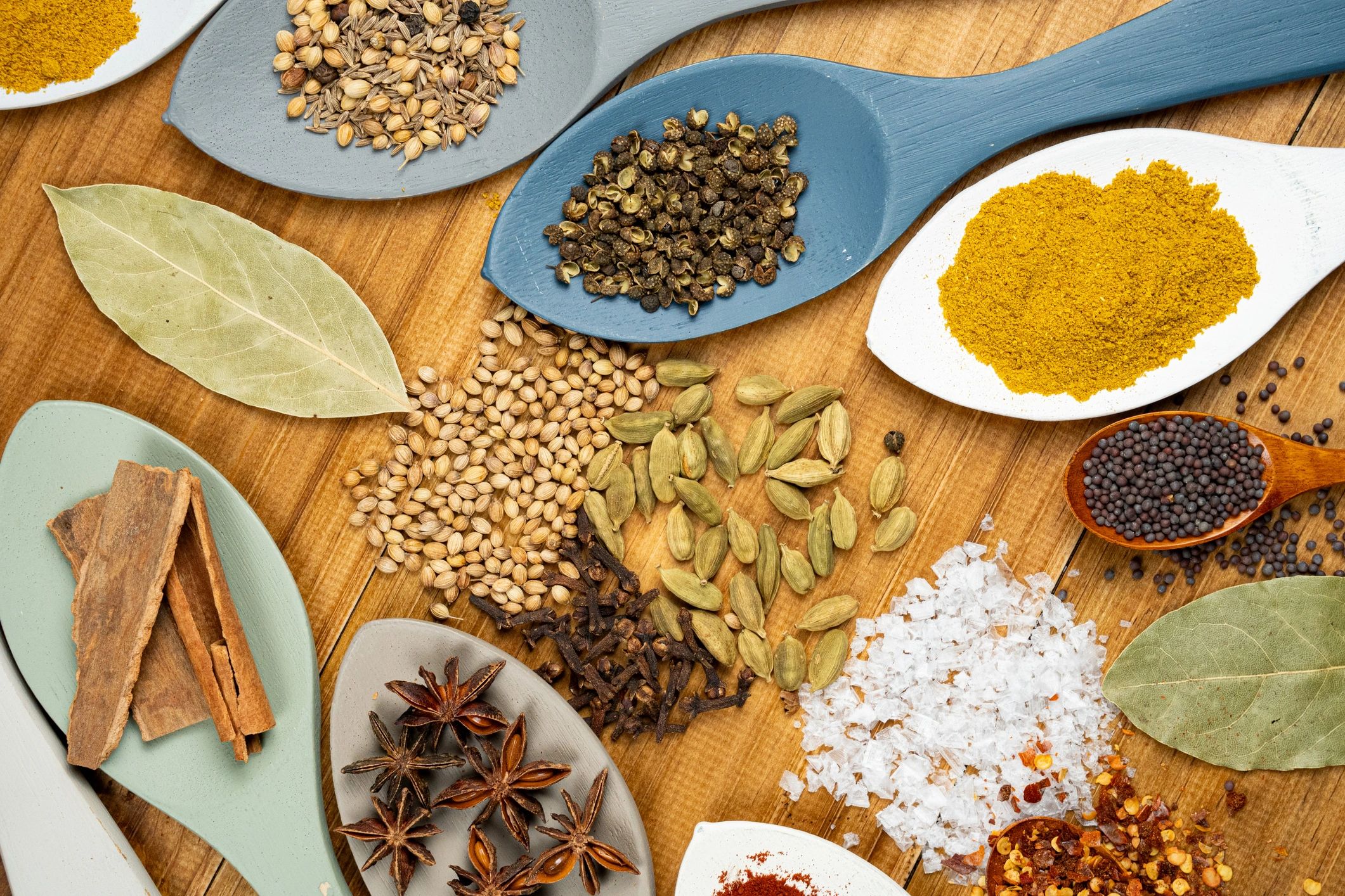 Colorful spices and herbs on wooden spoons